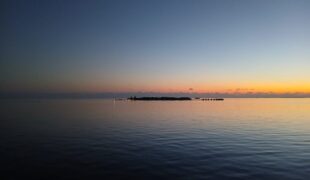 At sunrise, the horizon whispers new beginnings across a still sea.